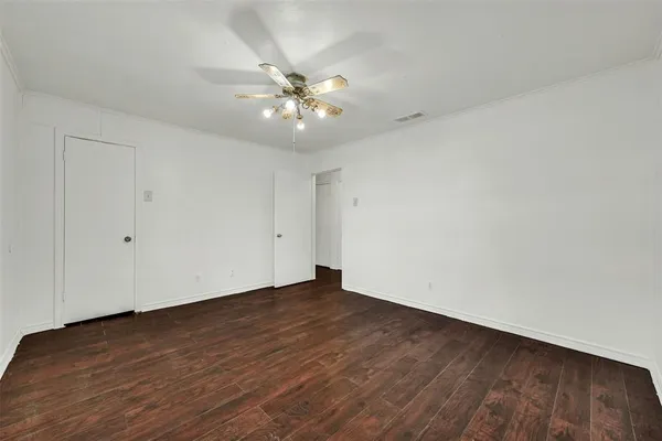 a view of an empty room with wooden floor