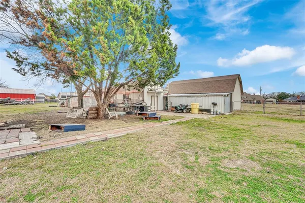a view of a house with a yard covered with snow and trees