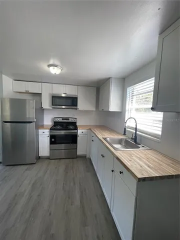 a kitchen with granite countertop a sink stove and refrigerator