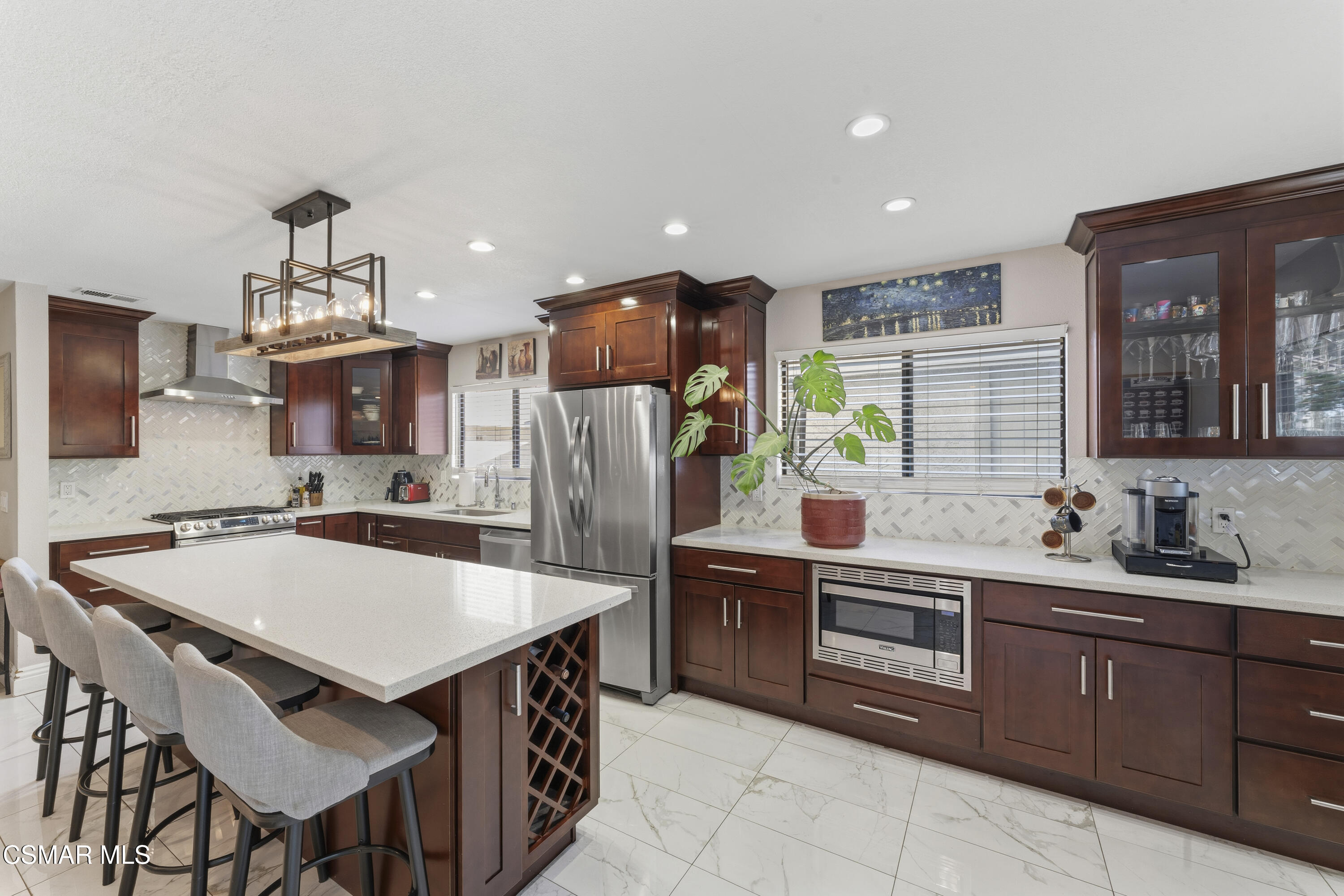 5775 Cochran Street Simi Valley, CA 93063 - Photo 8 of 33 a kitchen with stainless steel appliances kitchen island granite countertop a table chairs sink and refrigerator
