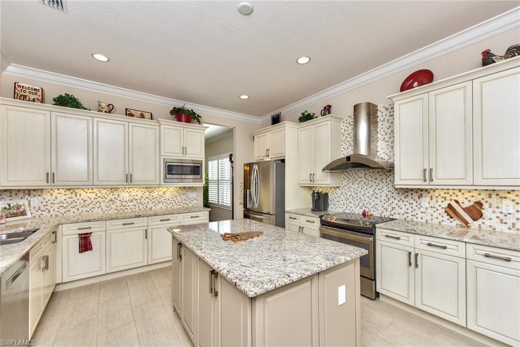 3424 Atlantic Circle Naples, FL 34119 - Photo 2 of 14 a kitchen with stainless steel appliances granite countertop a sink stove and refrigerator