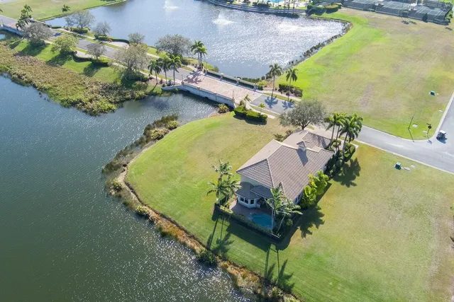 an aerial view of a house with a yard and lake view