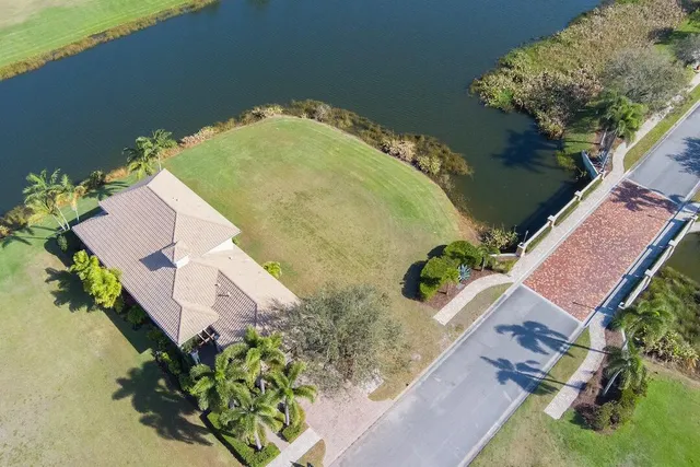 an aerial view of a house with a yard and lake view