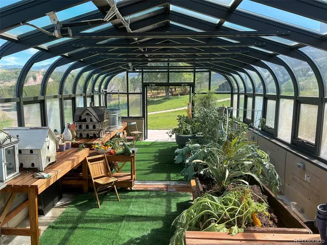 a view of swimming pool with lawn chairs and plants