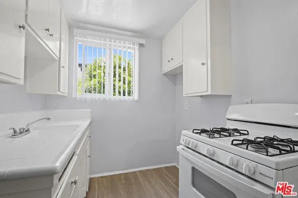 a kitchen with a sink stove and cabinets