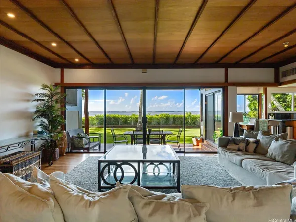 a living room with patio furniture and a floor to ceiling window