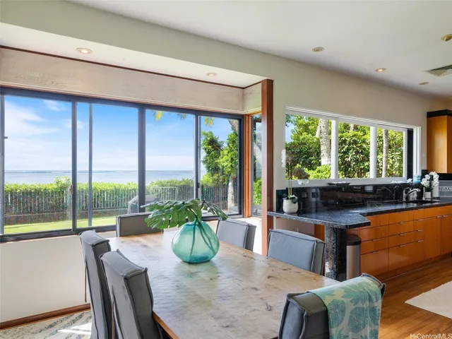 a dining room with furniture a large window and a kitchen view