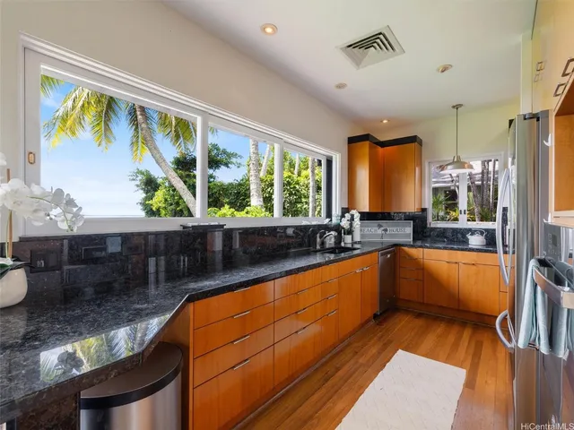 a kitchen with stainless steel appliances granite countertop a sink and wooden cabinets
