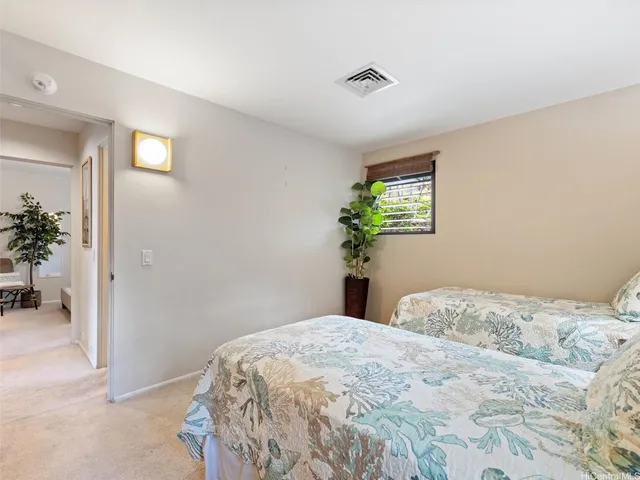 a bedroom with a bed and a potted plant