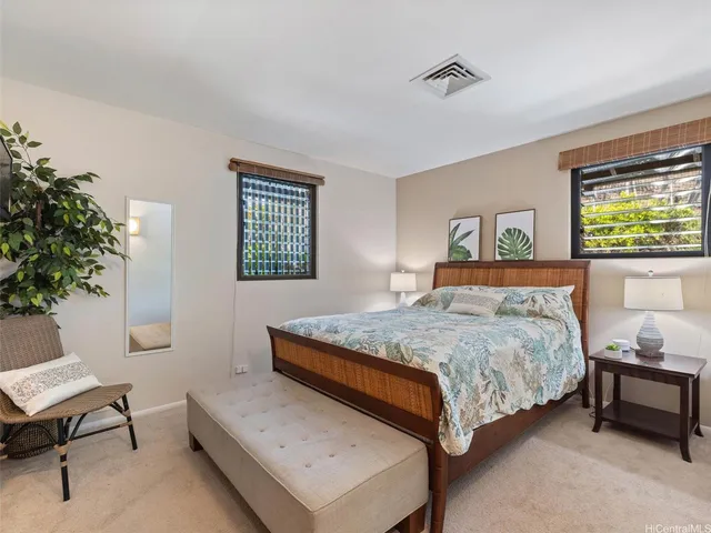 a bedroom with a bed table chair and a window