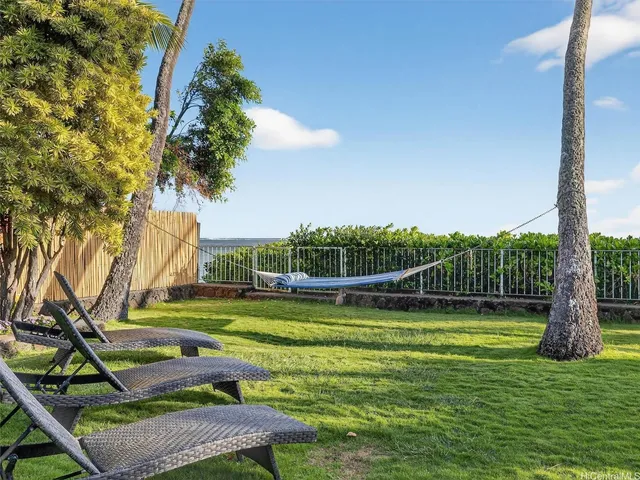 a view of a swimming pool with a yard and sitting area
