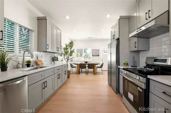 a kitchen with stainless steel appliances kitchen island granite countertop a sink a stove and a refrigerator
