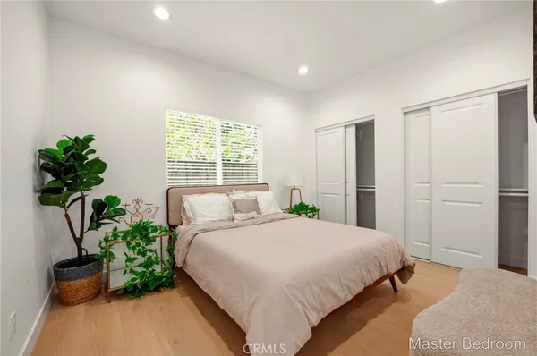 a bedroom with a bed potted plant and a window
