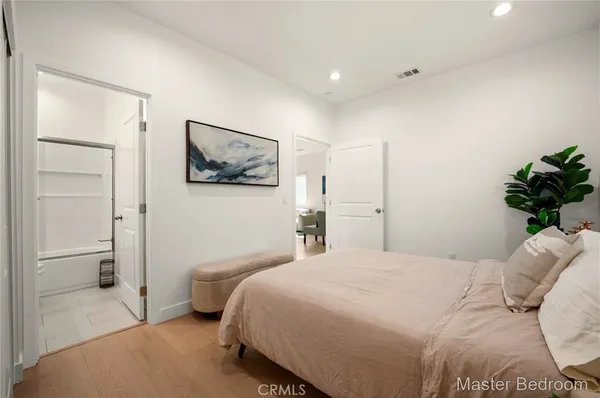 a bedroom with a bed and a painting on the wall