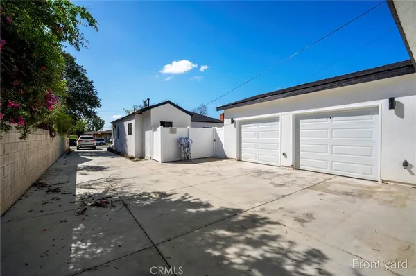 a view of a white house with a small yard