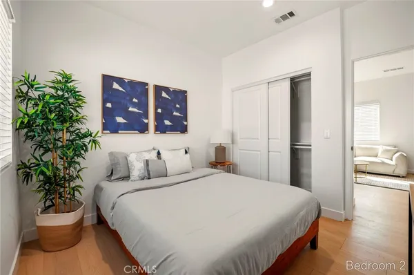 a bedroom with a bed and a potted plant