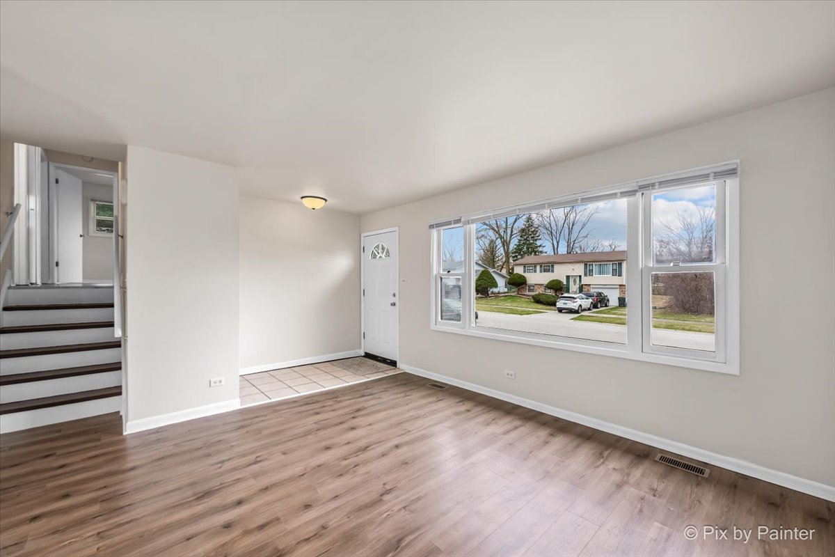 18951 Chestnut Avenue Country Club Hills, IL 60478 - Photo 5 of 23 a view of an empty room with a window and wooden floor