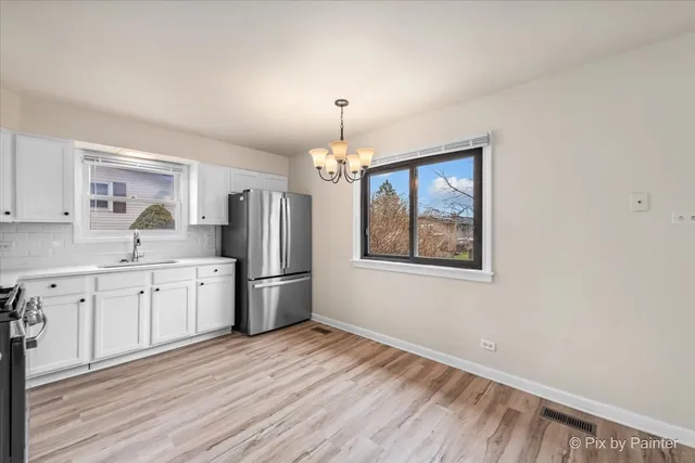 a kitchen with refrigerator cabinets and wooden floor