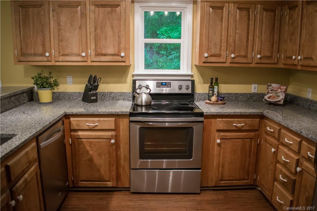 9205 Ladson Road Indian Land, SC 29707 - Photo 8 of 16 a kitchen with granite countertop wooden cabinets and a stove