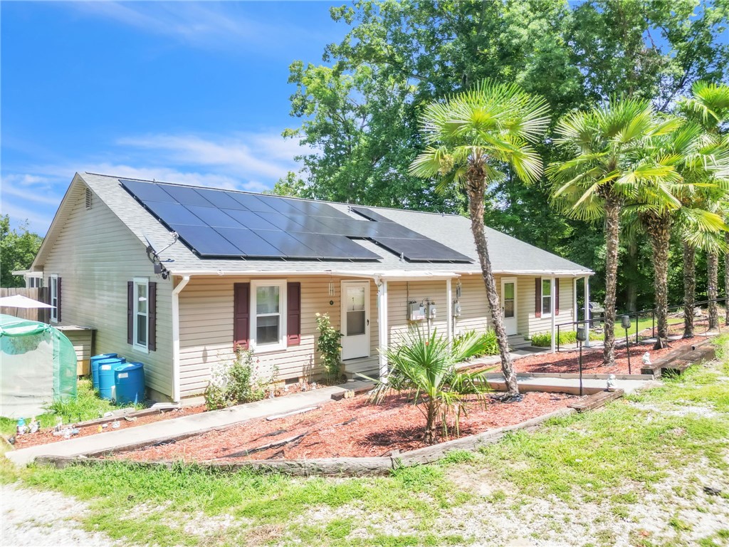 48 Tierra Drive Waterloo, SC 29384 - Photo 10 of 42 Solar panels line the roof of this classic ranch home nestled among mature palm trees.