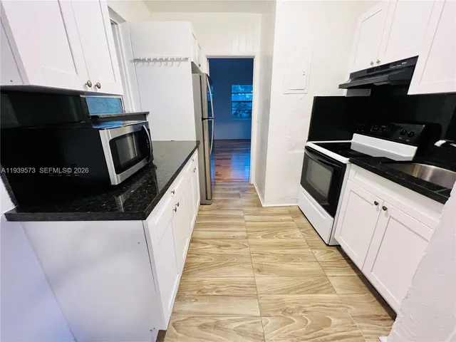 a kitchen with granite countertop a stove and a refrigerator