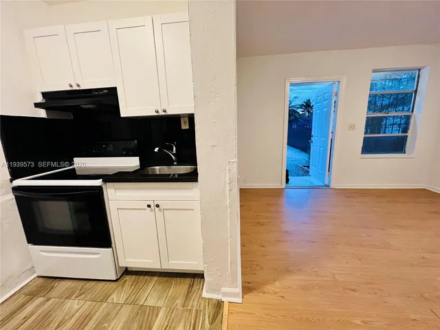 a kitchen with granite countertop a stove and a microwave