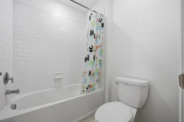 a white toilet sitting next to a bath tub