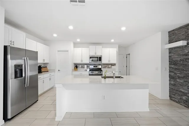 a kitchen with stainless steel appliances a refrigerator sink and microwave