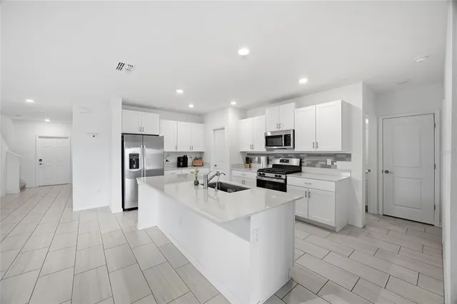 a kitchen with white cabinets and stainless steel appliances