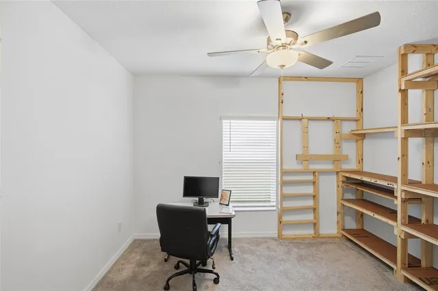 a view of a workspace with furniture and a window