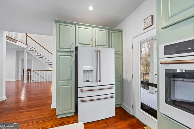 a view of a hallway with wooden floor and staircase