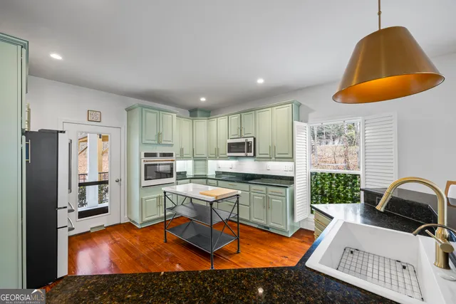 a living room with furniture a rug and kitchen view