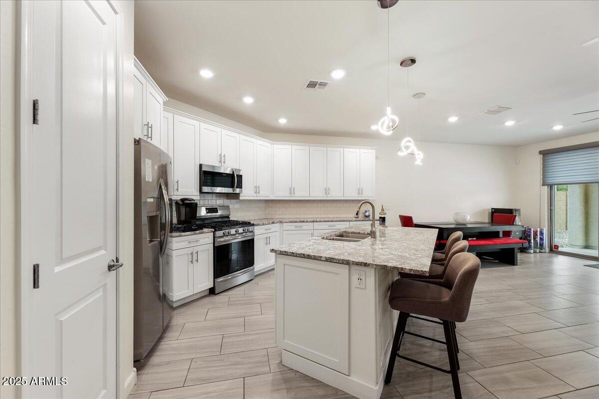 2745 West Pollack Street Phoenix, AZ 85041 - Photo 6 of 20 a kitchen with a sink stainless steel appliances and cabinets