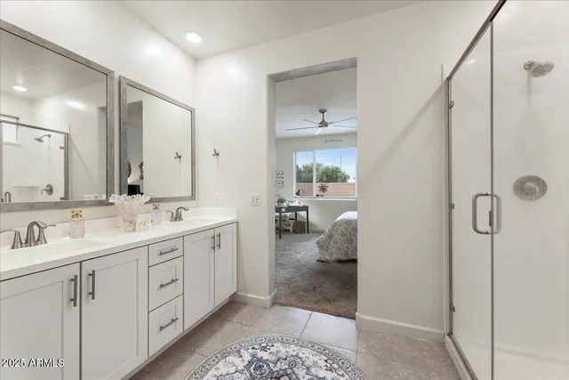 a spacious bathroom with a double vanity sink a mirror and shower