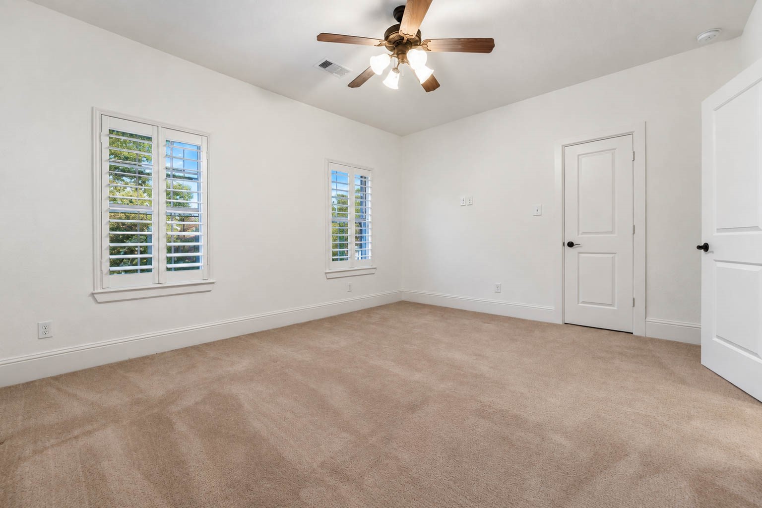 5403 Mesquite Ridge Street Fulshear, TX 77441 - Photo 29 of 42 The first upstairs bedroom is bright and comfortable, with soft carpet underfoot and two shuttered windows that let in the daylight. A ceiling fan keeps the room comfortable, and a roomy closet provides storage.