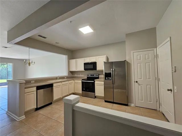 a large kitchen with cabinets and stainless steel appliances