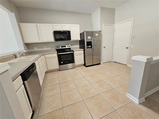 a kitchen with stainless steel appliances a refrigerator sink and microwave