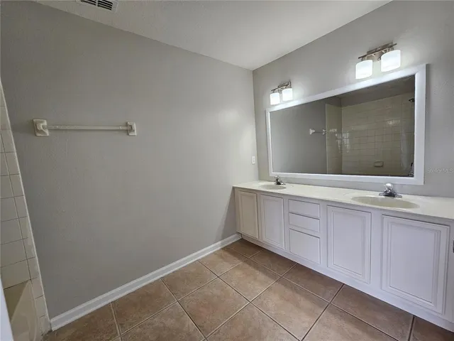 a bathroom with a double vanity sink and a mirror
