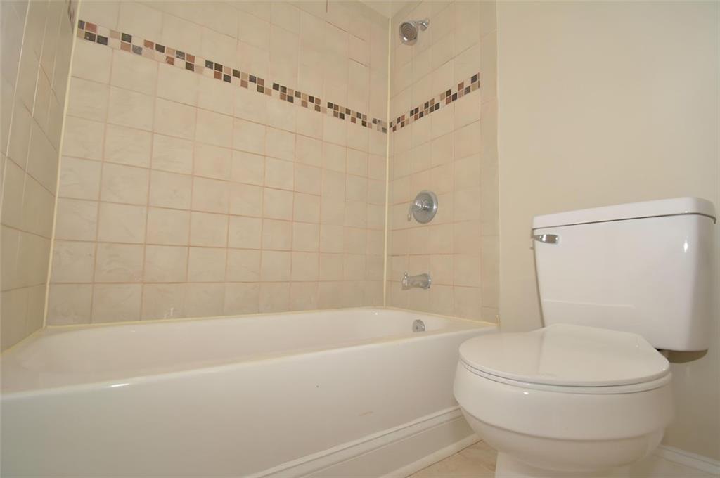 618 Tradwell Place Northeast, Unit BSMT Dacula, GA 30019 - Photo 13 of 20 a white toilet sitting next to a bath tub