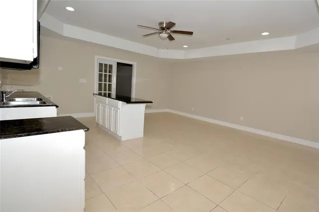 a kitchen with a sink a stove and white cabinets