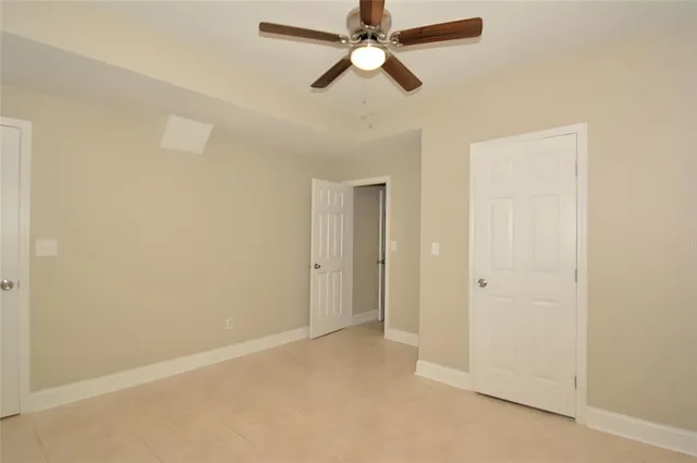 an empty room with a ceiling fan and a window