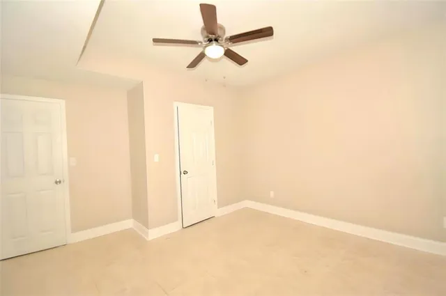 an empty room with a ceiling fan and a window