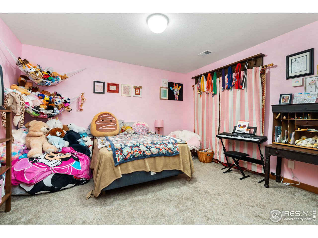 8265 Spinnaker Bay Drive Windsor, CO 80528 - Photo 19 of 40 a bedroom with a bed a dresser and a book shelf