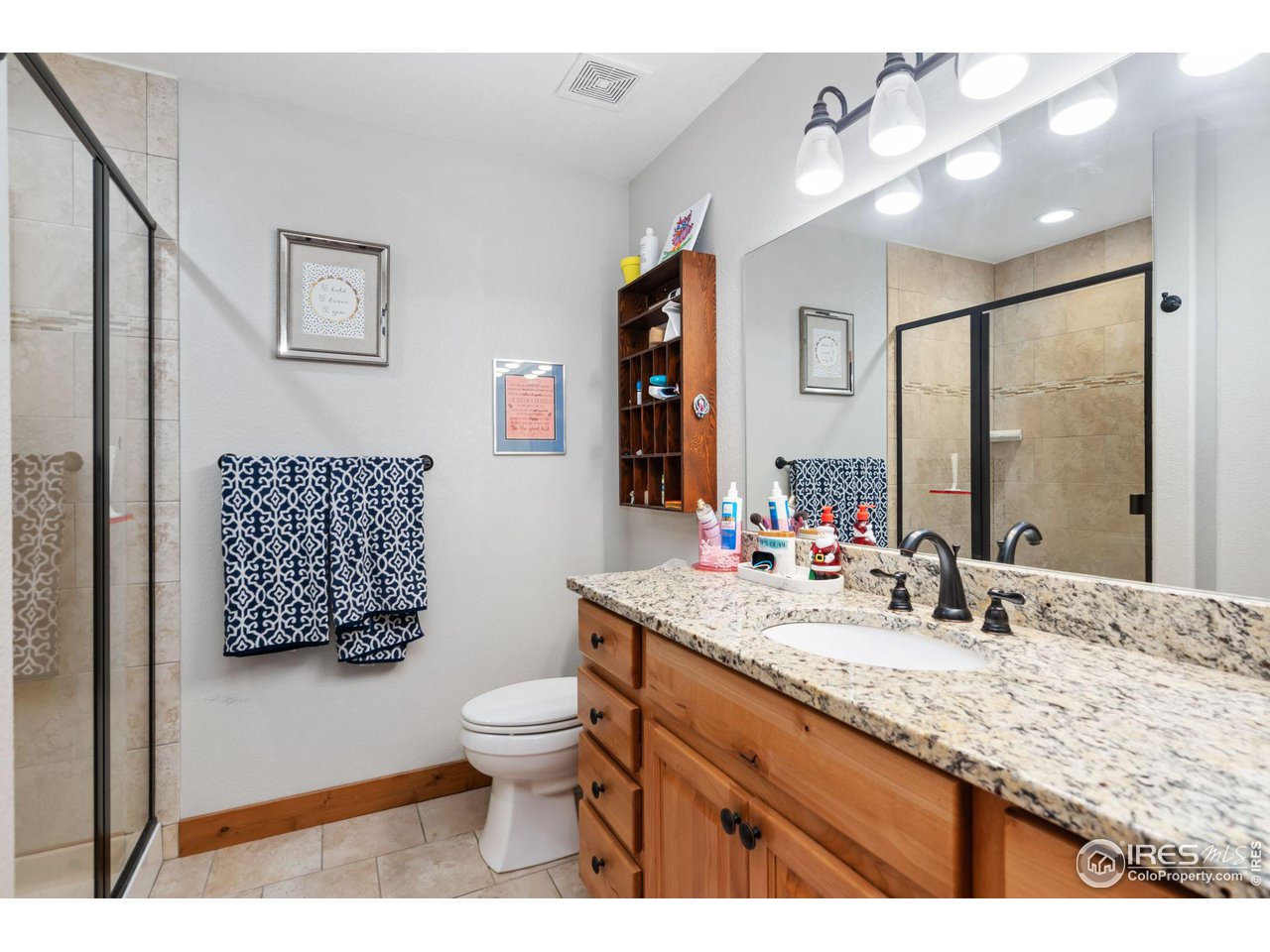 8265 Spinnaker Bay Drive Windsor, CO 80528 - Photo 22 of 40 a bathroom with a granite countertop sink mirror vanity and toilet