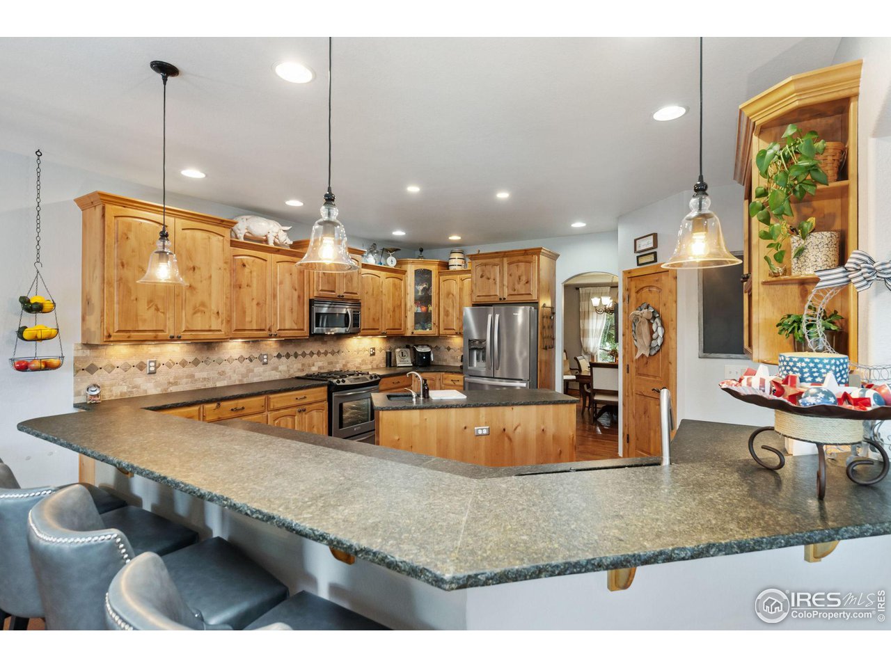 8265 Spinnaker Bay Drive Windsor, CO 80528 - Photo 7 of 40 a view of a kitchen with kitchen island a large counter top appliances and cabinets