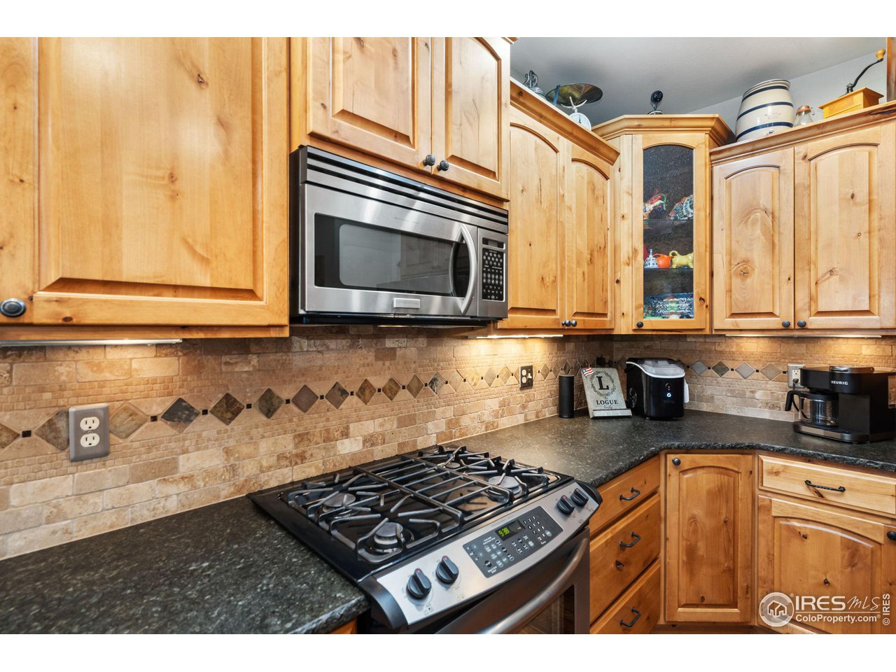 8265 Spinnaker Bay Drive Windsor, CO 80528 - Photo 9 of 40 a kitchen with stainless steel appliances granite countertop a stove a sink and a microwave