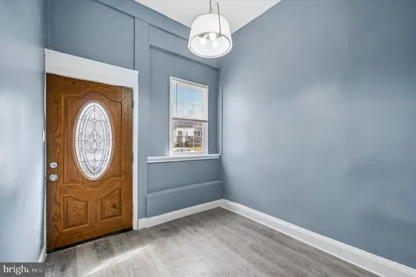 a view of a hallway with entryway wooden floor and a chandelier fan