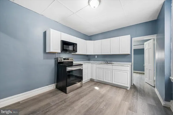 a kitchen with granite countertop a stove a sink and a microwave