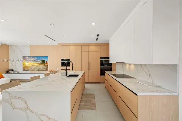 a large kitchen with stainless steel appliances lots of counter space and a sink