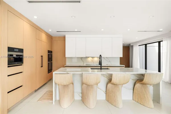 a kitchen with stainless steel appliances a table and chairs in it